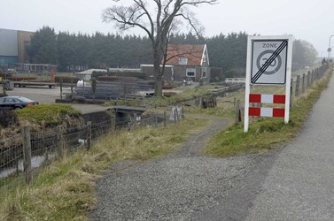 <p>De afweg met klinkers en brug naar de voormalige V.O.B.I.-fabriek, die hier aan de dijk gevestigd was, al voordat het bedrijventerrein werd ontwikkeld. </p>
